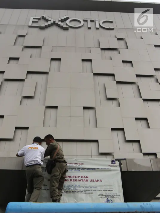 Petugas Satpol PP memasang banner penutup  saat menyegel Diskotek Exotic di Mangga Besar, Jakarta, Kamis (19/4). Petugas tidak memberi keterangan perihal penutupan diskotek yang sudah tidak aktif sejak 15 April 2018 lalu (Liputan6.com/Arya Manggala)