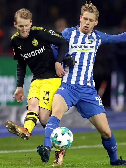 Pemain Borussia Dortmund Andre Schuerrle dan pemain Hertha Berlin, Arne Maier berebut bola dalam lanjutan Bundesliga di Olympiastadion Berlin, Sabtu (20/1). Dortmund selamat dari kekalahan usai Shinji Kagawa mencetak gol penyeimbang 1-1. (AP/Michael Sohn)