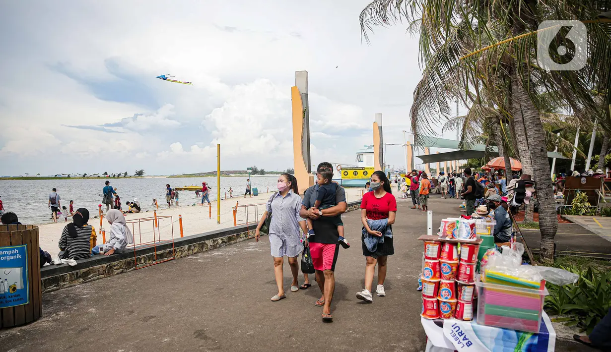 Wisatawan berjalan di Pantai Ancol, Jakarta, Sabtu (25/12/2021). Libur Natal dimanfaatkan masyarakat berwisata ke Pantai Ancol, Kawasan Pantai Ancol merupakan salah satu objek wisata yang kerap menjadi tujuan wisatawan saat mengisi waktu liburan. (Liputan6.com/Faizal Fanani)
