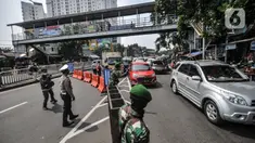 Petugas gabungan mengatur lalu lintas saat penyekatan mobilitas di Jalan Basuki Rahmat, Jakarta Timur, Kamis (15/7/2021). Polda Metro Jaya memperluas area penyekatan selama PPKM Darurat menjadi 100 titik mulai pukul 06.00-22.00 WIB guna mengurangi mobilitas. (merdeka.com/Iqbal S Nugroho)