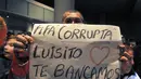 Sambil menanti kedatangan Luis Suarez di Bandara Montevideo, Carrasco, (26/6/2014), salah satu warga Uruguay membentangkan tulisan berbunyi "FIFA korup - Luis, kita mencintai dan mendukungmu". (REUTERS/Carlos Pazos)