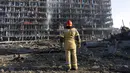Seorang petugas pemadam kebakaran melihat kerusakan setelah serangan sebuah pusat perbelanjaan di Kiev, Ukraina, Senin (21/3/2022). Delapan orang tewas dalam serangan tersebut. (AP Photo/Rodrigo Abd)