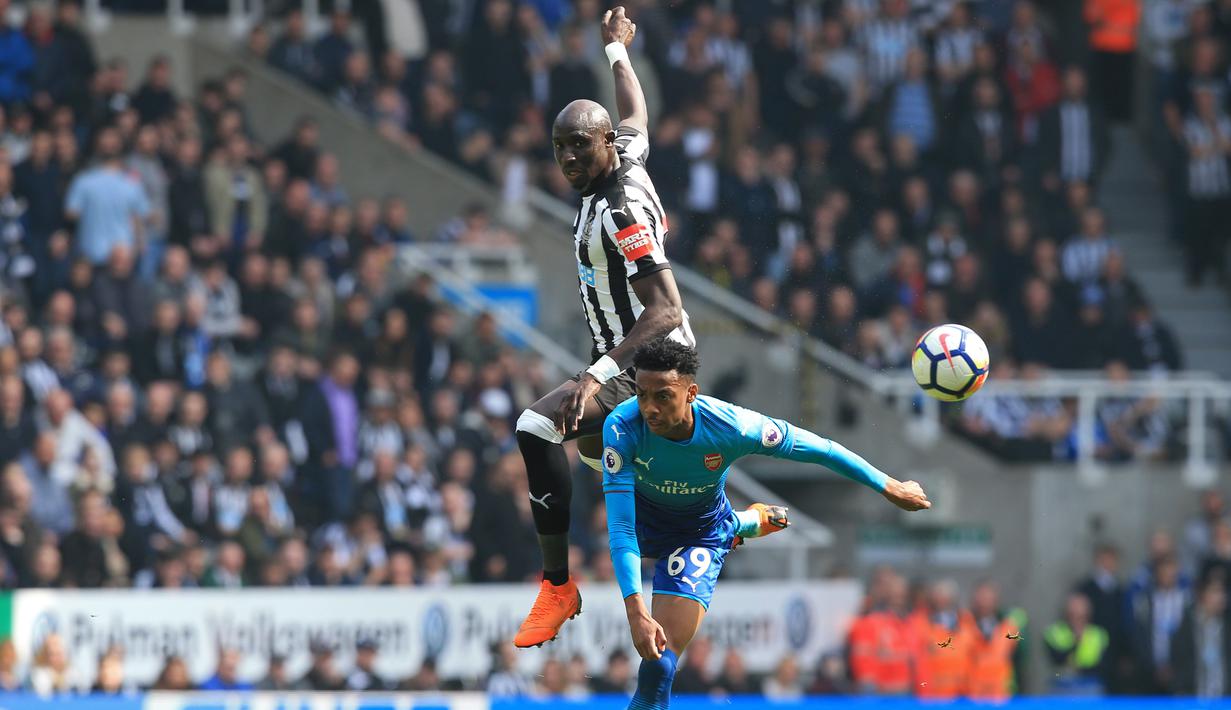 Duel pemain Arsenal, Joe Willock (bawah) dan pemain Newcastle United, Mohamed Diame pada lanjutan Premier League di St James' Park, Newcastle, (15/4/2018). Newcastle menang 2-1. (AFP/ Lindsey Parnaby)