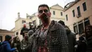 Seorang pria berpakaian seperti zombie bersiap mengikuti pembukaan Carnival of Venice 2017, Italia (11/2). Karnaval ini akan berlangsung hingga 28 Februari di pusat kota Venesia, Italia. (AFP/Marco Bertorello)