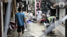 Warga beraktivitas di tengah banjir yang merendam permukiman warga di Kemang Timur XI, Jakarta, Minggu (21/2/2021). Warga berharap pemerintah segera memperbaiki longsor agar banjir tidak berkepanjangan. (merdeka.com/Iqbal S. Nugroho)