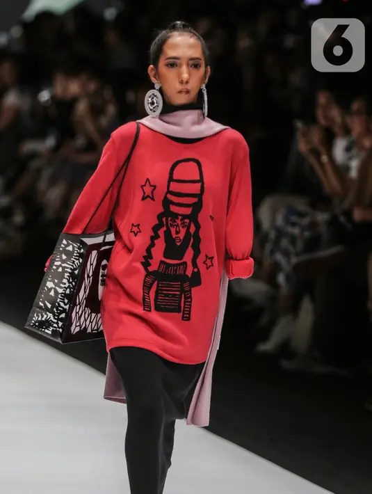 Model disabilitas mengenakan busana rancangan kolaborasi Cotton Ink x Intoart yang digawangi British Council pada Jakarta Fashion Week 2020 di Senayan, Kamis (24/10/2019). Kolaborasi ini menampilkan model disabilitas yang terdiri dari down syndrome, tuna daksa dan tuli. (Liputan.com/Johan Tallo)
