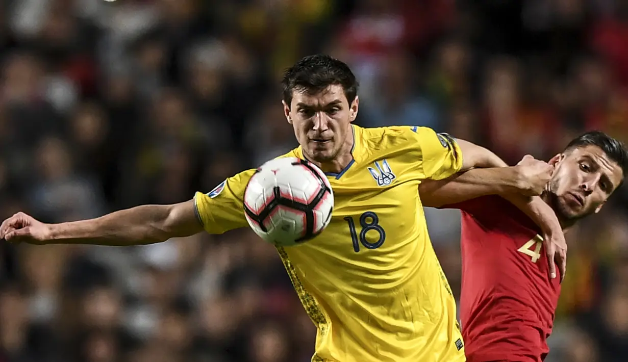 Striker Ukraina, Roman Yaremchuk, berusaha melewati bek Portugal, Ruben Dias, pada laga Kualifikasi Piala Eropa 2020 di Stadion Luz, Lisbon, Jumat (22/3). Kedua negara bermain imbang 0-0. (AFP/Patricia De Melo Moreira)