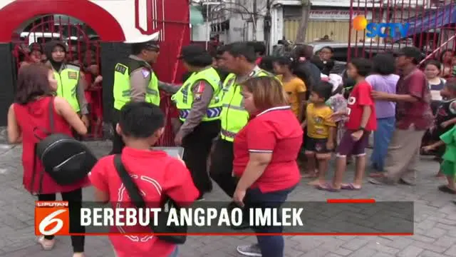 Puluhan warga Surabaya berebut mendapatkan angpau di Klenteng Pak Kik Bio Thian Siang Tee, di Jalan Jagalan, Surabaya.