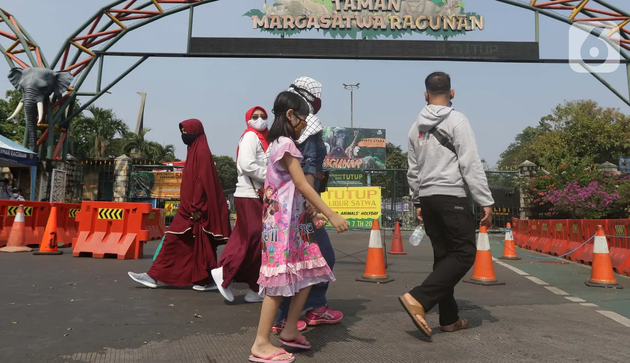 Calon pengunjung melintas di depan gerbang utama kawasan Kebun Binatang Ragunan, Jakarta, Minggu (16/5/2021). Sejumlah kawasan wisata di DKI Jakarta ditutup sementara untuk umum hingga 18 Mei 2021 untuk pemberlakukan penguatan protokol kesehatan COVID-19. (Liputan6.com/Helmi Fithriansyah)