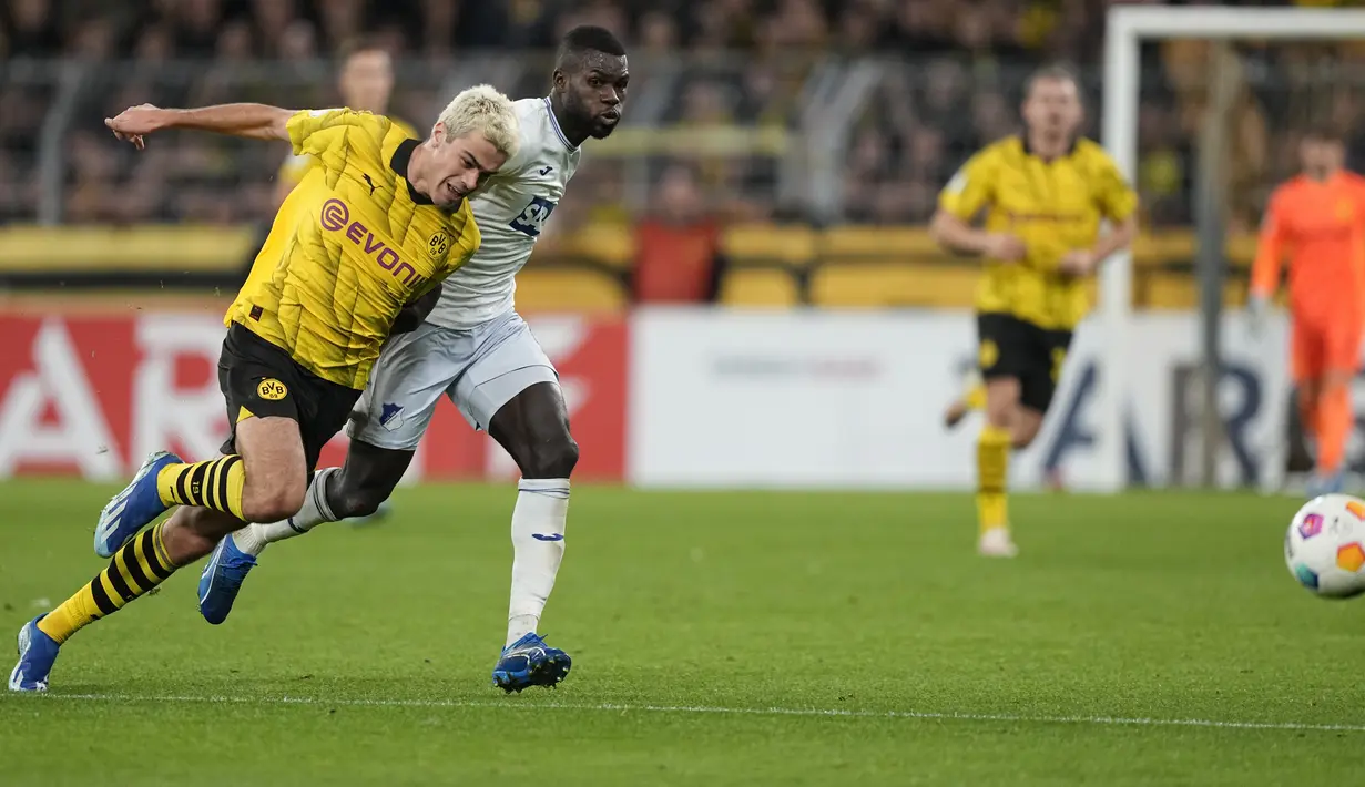 Gelandang Borussia Dortmund Giovanni Reyna berebut bola dengan penyerang TSG Hoffenheim Ihlas Bebou pada lanjutan laga putaran DFB Cup atau Piala Jerman di Signal Iduna Park, Kamis (2/11) dini hari WIB. (AP Photo/Martin Meissner)