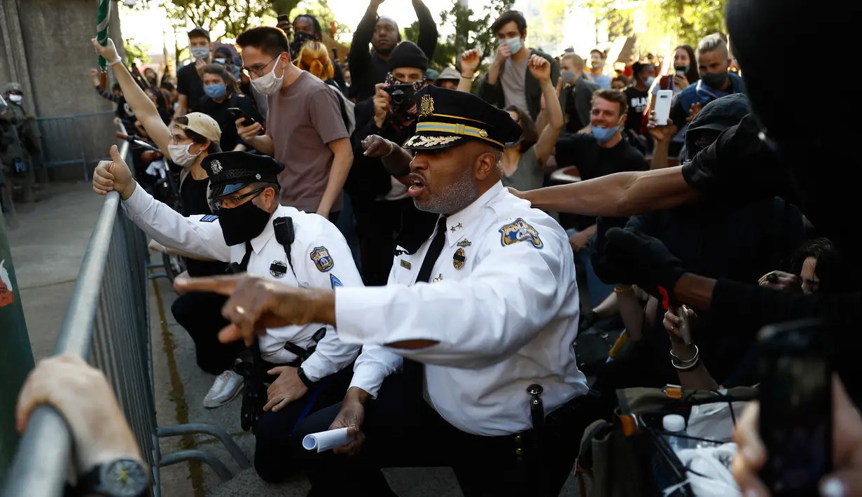 Deputi Komisaris Polisi Philadelphia, Melvin Singleton (tengah) berlutut dan meminta polisi lain bergabung dengannya saat pawai menyerukan keadilan atas kematian George Floyd di luar markas besar Kepolisian Philadelphia di Philadelphia, Senin (1/6/2020). (AP/Matt Slocum)