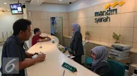 Petugas melayani nasabah di Bank Mandiri Syariah di Jakarta, Kamis (14/7). Sejumlah bank syariah mengaku siap menjadi bank persepsi, Jakarta, Kamis (14/7). (Liputan6.com/Angga Yuniar)