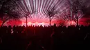 Orang-orang menonton pertunjukan laser saat perayaan Tahun Baru di Bucharest, Rumania, Sabtu (1/1/2022). Ribuan orang berkumpul di tepi danau untuk menghadiri konser dan menonton kembang api serta pertunjukan laser pada perayaan Tahun Baru. (AP Photo/Andreea Alexandru)