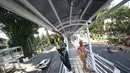 Pekerja mengecat pagar dan atap jembatan penyeberangan menuju halte Transjakarta di kawasan Cawang, Jakarta, Rabu (5/4). Pengecatan dilakukan untuk menjaga halte agar tetap bersih dan terawat. (Liputan6.com/Immanuel Antonius)