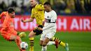 Pemain PSG, Kylian Mbappe (kanan) berusaha melewati kiper Borussia Dortmund, Gregor Kobel pada laga lanjutan Grup F Liga Champions 2023/2024 di Signal Iduna Park, Dortmund, Jerman, Kamis (14/12/2023) dini hari WIB. (AFP/Ina Fassbender)