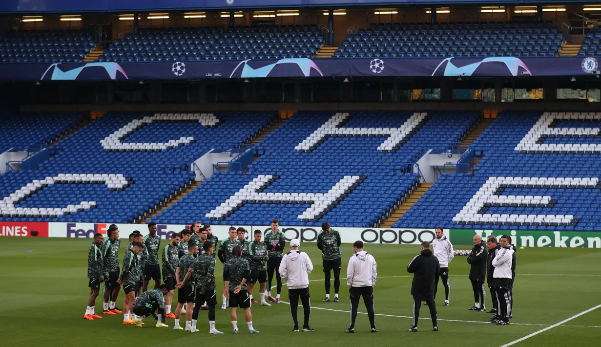 <p>Para pemain Real Madrid berbicara di lapangan selama sesi latihan di Stamford Bridge di London pada 17 April 2023. (AFP/Adrian Dennis)</p>