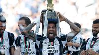 Bek Juventus, Dani Alves mengangkat trofi Liga Italia di Juventus Stadium, Turin, (21/5). Bagi Juveventus, ini merupakan scudetto ke-33 atau yang keenam secara beruntun. (AP Photo/Antonio Calanni)
