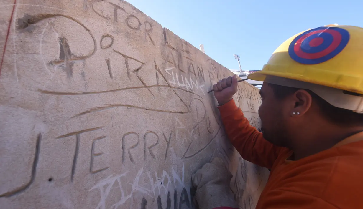 Seorang suporter saat menyelesaikan pembangunan stadion baru di Asuncion, Paraguay (22/6). Pembangunan stadion memiliki nilai proyek USD 15 juta atau Rp 199 miliar tersebut. (AFP Photo/Norberto Duarte)