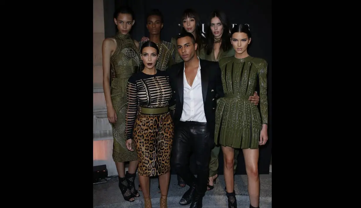 Istri Kanye West itu berpose bersama creative director Balmain, Olivier Rousteing (tengah) di Paris Fashion Week 2014, Rabu (9/7/14). (AFP PHOTO/Thomas Samson)