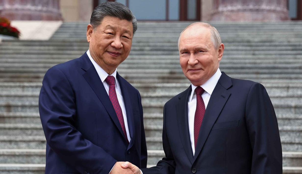 Presiden Rusia Vladimir Putin (kanan) dan Presiden China Xi Jinping berjabat tangan saat upacara penyambutan di Balai Besar Rakyat, Beijing, China, pada Rabu 20 Mei 2026. (Alexander Kazakov, Sputnik, Kremlin Pool Photo via AP)