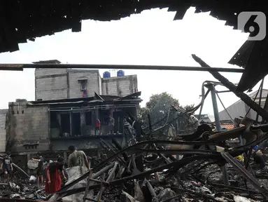Warga mencari sisa barang akibat terbakar kios pasar Kambing, Jakarta, Rabu (9/8/2023). (merdeka.com/imam buhori)