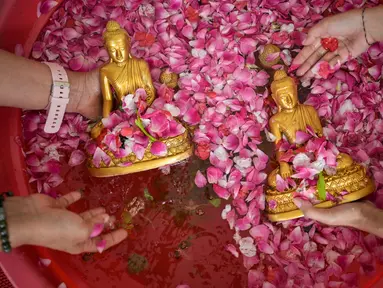 Warga membersihkan patung Buddha dalam persiapan perayaan Tahun Baru Imlek 2577 Kongzili di Vihara Buddhayana, Surabaya, Jawa Timur pada Senin 9 Februari 2026. Membersihkan patung Buddha merupakan ritual sakral tahunan yang dilakukan sebagai simbol penyucian diri dan penghormatan dalam menyambut Tahun Baru Imlek. (JUNI KRISWANTO/AFP)