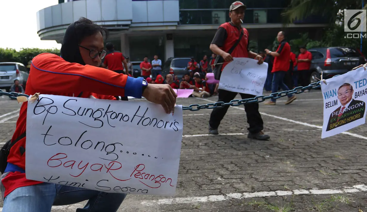 Seorang pria mantan karyawan 7-Eleven memasang poster saat melakukan aksi di Jakarta, Rabu (22/2). Jumlah total pesangon untuk anggota serikat pekerja PT Modern Putra Indonesia itu sebesar Rp 17,5 miliar. (Liputan6.com/Angga Yuniar)