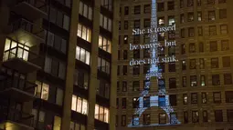 Proyeksi Menara Eiffel ditampilkan di sisi bangunan Flatiron New York City, Rabu (18/11). Gambar yang menampilkan tulisan 'She is tossed by waves but does not sink' itu bentuk solidaritas terkait serangan teror Paris. (Andrew Burton/Getty Images/AFP)