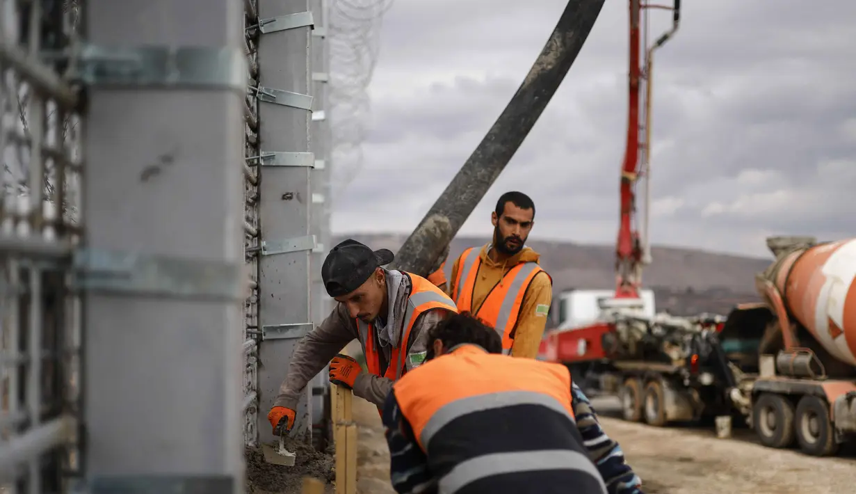 Sementara Lebanon dan Perserikatan Bangsa Bangsa (PBB) menganggap pembangunan di luar Garis Biru sebagai pelanggaran wilayah. Tampak dalam foto, pekerja Israel sedang menuangkan beton saat bekerja di pagar perbatasan yang memisahkan Israel utara dari Lebanon selatan pada 16 November 2025. (Jalaa MAREY/AFP)