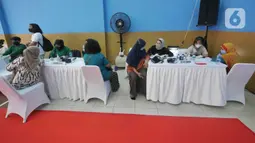 Petugas mengecek kesehatan warga saat gelaran Vaksin Covid-19 Serentak di GOR Radio Dalam, Jakarta Selatan, Selasa (8/3/2022). Vaksinasi serentak digelar di seluruh Indonesia yang diselenggarakan Kepolisian RI dengan target penyaluran vaksin sebanyak 1.114.750 dosis. (Liputan6.com/Herman Zakharia)