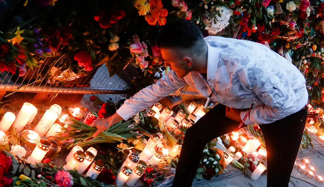 Seorang pria menyalakan lilin di lokasi terjadinya serangan truk di Stockholm, Swedia, Minggu (9/4). Sebuah truk yang dibajak menabrakkan diri ke kerumunan pejalan kaki pada Sabtu (8/4) dan menewaskan empat orang. (AP Photo / Markus Schreiber)