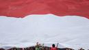 Suporter membentangkan merah putih raksasa saat laga Timnas Indonesia melawan Timor Leste pada laga SEA Games di Stadion MPS, Selangor, Minggu (20/8/2017). Indonesia menang 1-0 atas Timor Leste. (Bola.com/Vitalis Yogi Trisna)