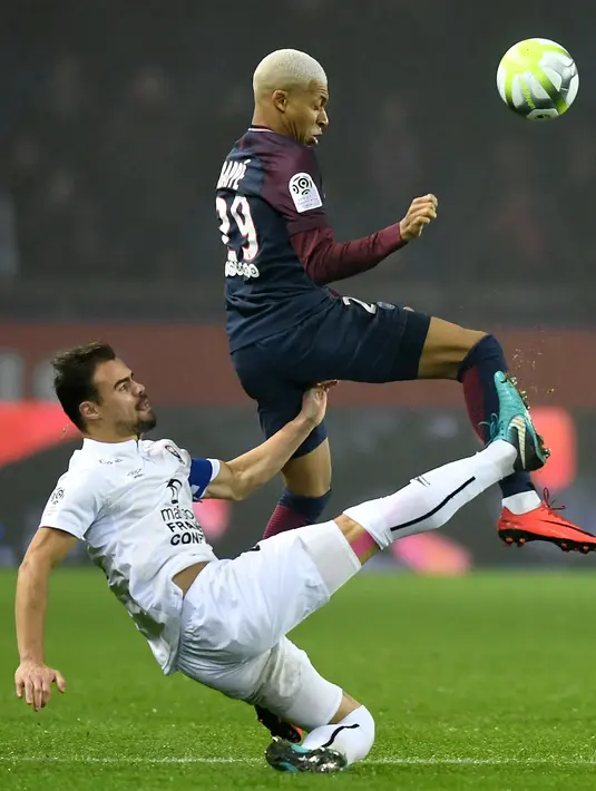 Pemain PSG, Kylian MBappe (atas) berebut bola dengan pemain Caen, Damien Da Silva pada lanjutan Ligue 1 Prancis di Parc des Princes stadium, Paris, (20/12/2017). PSG menang 3-1. (AFP/Franck Fife)
