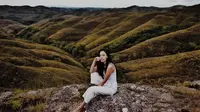 Wanita berdarah Indonesia-Swiss ini berpose dengan latar belakang Bukit Warinding Sumba yang sangat menakjubkan. Menggunakan pakaian serba putih, Anggika tampak santai tanpa menggunakan alas kaki. (Liputan6.com/IG/@anggikabolsterli)