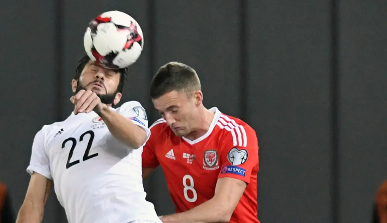 Duel Udara pemain Georgia, Giorgi Navalovsky (kiri) dan Pemain Wales, Andy King pada kualifikasi Piala Dunia 2018 grup D di Boris Paichadze Dinamo Arena, Tbilisi (06/10/2017). Wales menang 1-0. (AFP/Vano Shlamov)