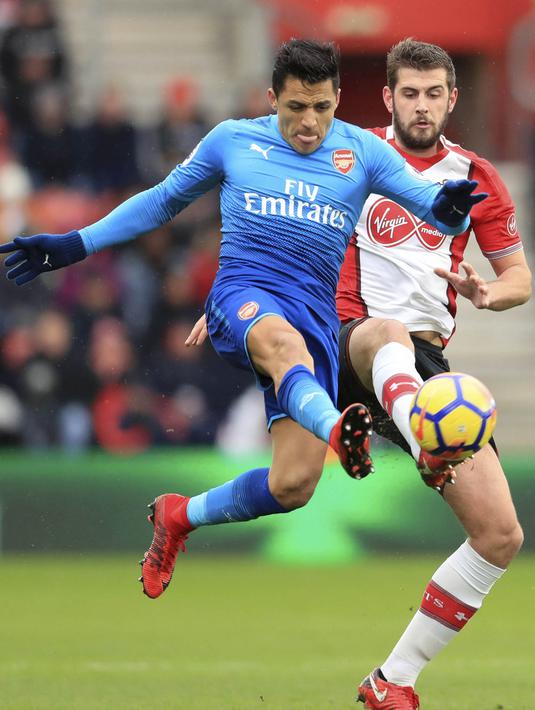 Striker Arsenal, Alexis Sanchez, berebut bola dengan bek Southampton, Jack Stephens, pada laga Premier League di Stadion St Mary's, Minggu (10/12/2017). Arsenal bermain imbang 1-1 dengan Southampton. (AP/Adam Davy)