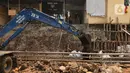 Alat berat mengeruk beton turap saluran air yang longsor di kawasan Jagakarsa, Jakarta, Kamis (17/9/2020). Selain karena hujan lebat, longsor diduga karena erosi tanah akibat pembuangan saluran air pencuci piring dan toilet dari warung makan di sekitar bantaran. (Liputan6.com/Immanuel Antonius)