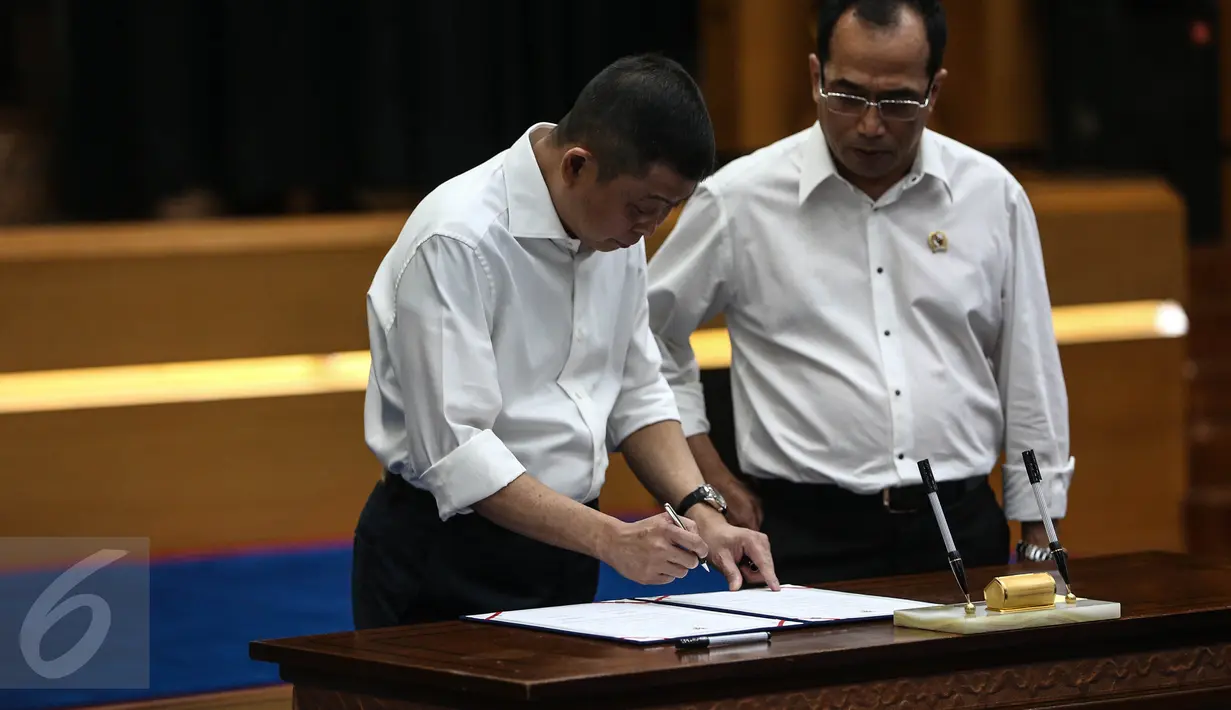 Mantan Menhub Ignasius Jonan menandatangani dokumen sertijab menteri disaksikan Menhub Budi Karya Sumadi di Gedung Kemenhub, Jakarta, Kamis (28/7). Budi Karya resmi menjadi Menhub menggantikan Ignasius Jonan. (Liputan6.com/Faizal Fanani)
