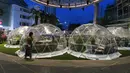 Seorang wanita berjalan melewati dining dome, instalasi tempat makan berbentuk kubah yang membantu mencegah penyebaran COVID-19, di Capitol Singapore Outdoor Plaza, Singapura, 21 Oktober 2020. (Xinhua/Then Chih Wey)