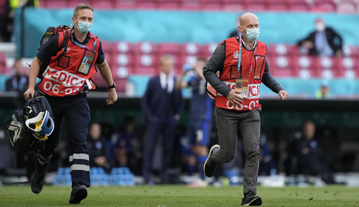 Tim medis sangat berjasa pada momen tak terduga seperti ini. Mereka lari dengan kecepatan penuh dari seberang lapangan sambil membawa peralatan medis mereka. Dengan sigap mereka memberikan pertolongan kepada Christian Eriksen hingga dapat sadarkan diri. (Foto:  AFP/Pool/Martin Meissner)