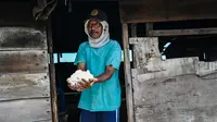 Seorang petani memegang garam yang sedang diproses dengan cara tradisional di sebuah tambak di Lamnga, pinggiran Banda Aceh, Aceh, Selasa (7/3/2023). Produksi garam Aceh per tahun 11.000 ton, sementara kebutuhan konsumsi per tahun 9.688 ton. (CHAIDEER MAHYUDDIN/AFP)