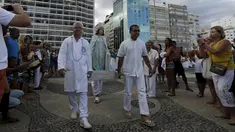 Sejumlah pengikut agama Afro - Brazilian Umbanda membawa persembahan untuk Iemanja, di Pantai Copacabana di Rio de Janeiro, Brasil, (29/12). Iemanja merupakan dewi laut yang dipuja oleh agama tersebut. (REUTERS/Ricardo Moraes)