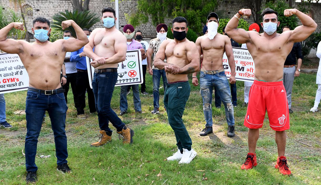 Pemilik dan pelatih gym memamerkan otot mereka saat protes menuntut pemerintah membuka kembali pusat kebugaran di Amritsar, India, Minggu (7/6/2020). Mereka meminta aktivitas tempat olahraga gym juga diizinkan buka setelah pelonggaran lockdown, bukan hanya kegiatan perekonomian. (NARINDER NANU/AFP)