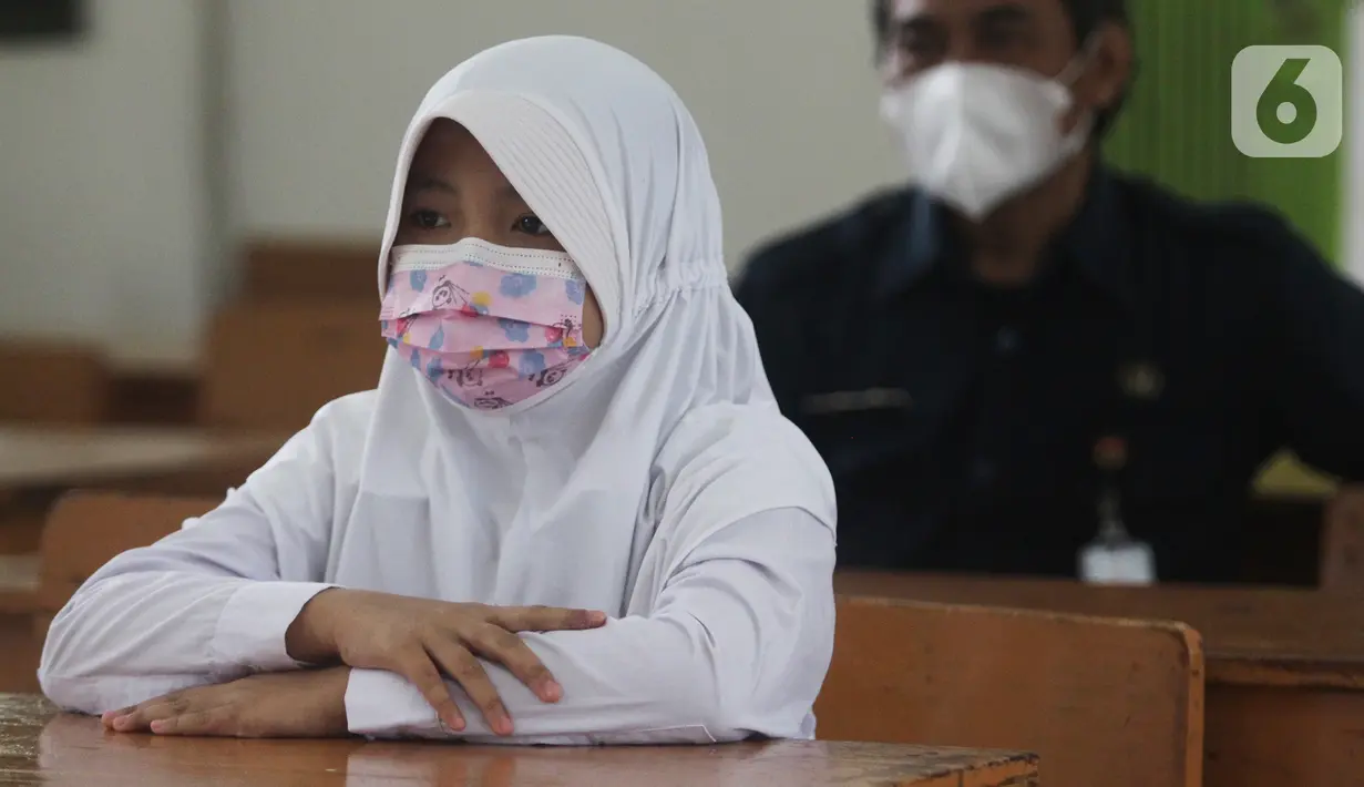 Seorang murid menunggu untuk mendapatkan vaksin tetanus di Madrasah Ibtidaiyah (MI) Negeri 7, Cengkareng Timur, Jakarta Barat, Selasa (7/12/2021). Sebanyak 1.600 murid SD dan MI di wilayah Kelurahan Cengkareng Timur menjalani suntik imunisasi TD dan TDaP. (Liputan6.com/Johan Tallo)