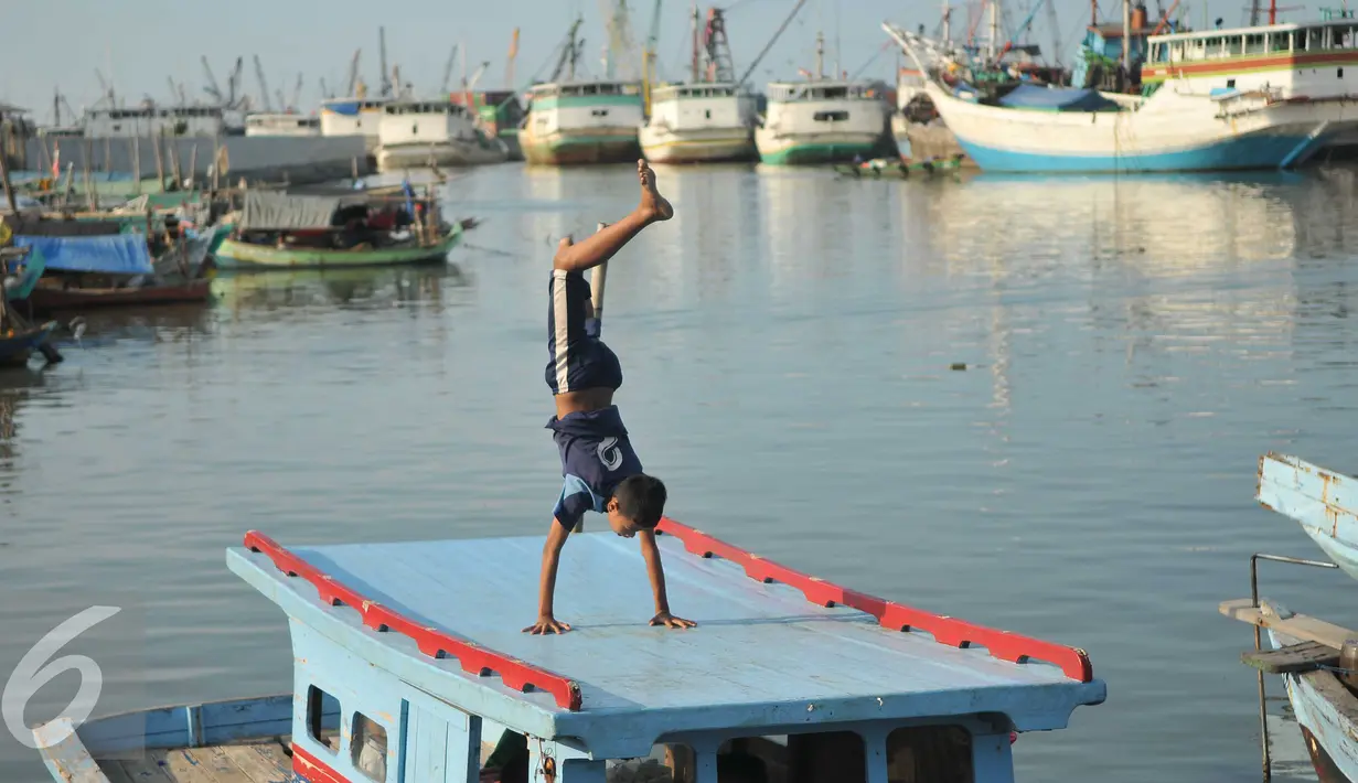 Aksi seorang anak di atas kapal di kawasan Luar Batang, Penjaringan, Jakarta, Senin (28/3). Pemprov DKI Jakarta menargetkan pembangunan 300 Ruang Publik Terpadu Ramah Anak (RPTRA) di seluruh kawasan Jakarta. (Liputan6.com/Gempur M Surya) 