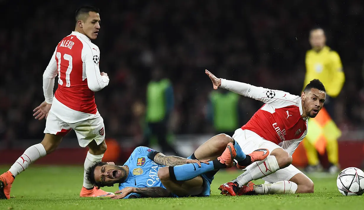 Gelandang Arsenal, Francis Coquelin, menjatuhkan bek sayap Barcelona, Dani Alves. Dua gol kemenangan Barca terjadi pada babak kedua melalui kaki Lionel Messi. (Reuters/Dylan Martinez)