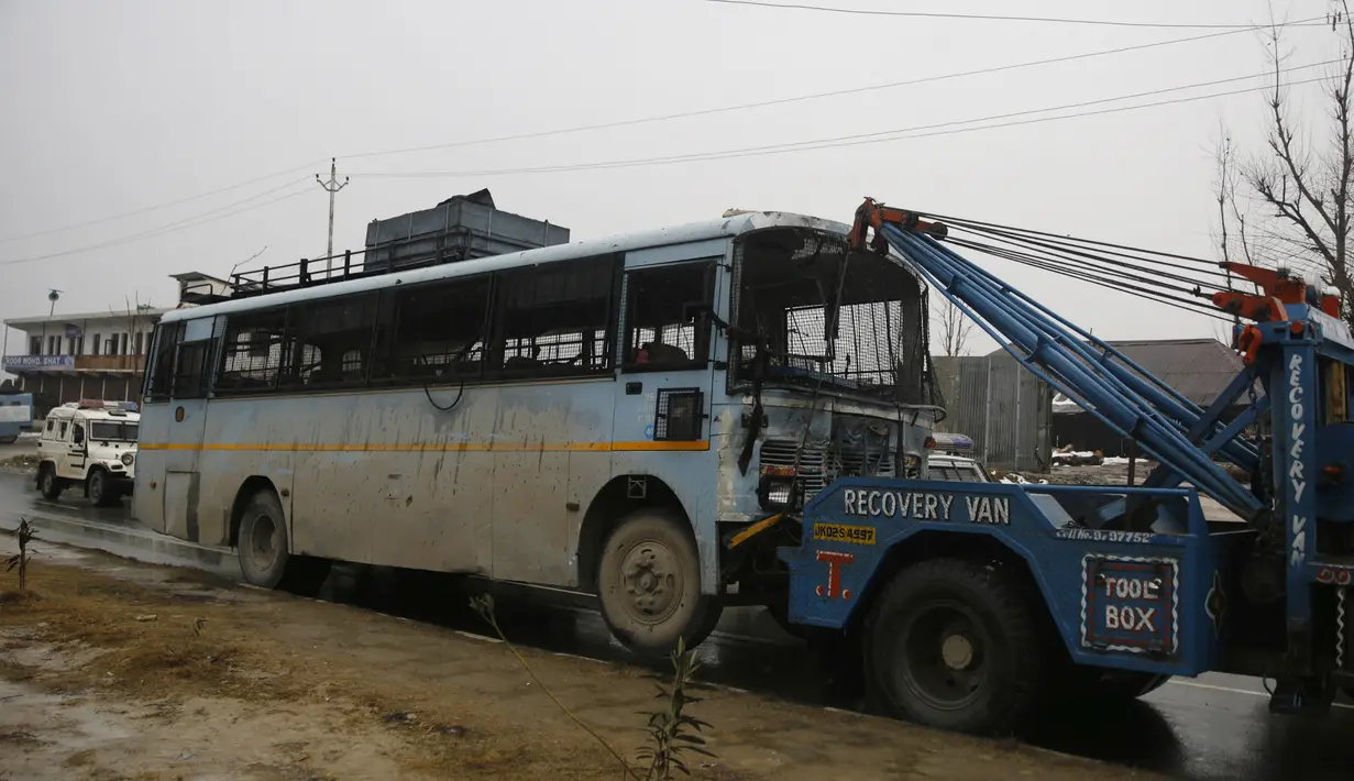 Sebuah bus yang rusak dibawa setelah ledakan bom mobil di Lethpora di distrik Pulwama, Kashmir, India (14/2). Menurut kesaksian dari seorang perwira polisi mobil bermuatan bom tersebut meledak usai menabrak konvoi pasukan CRPF. (AFP Photo/STR)