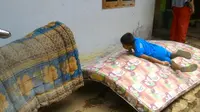 Seorang anak asyik bermain di kasur-kasur yang dijemur untuk membunuh kuman scabies. (Foto: Liputan6.com/Muhamad Ridlo)
