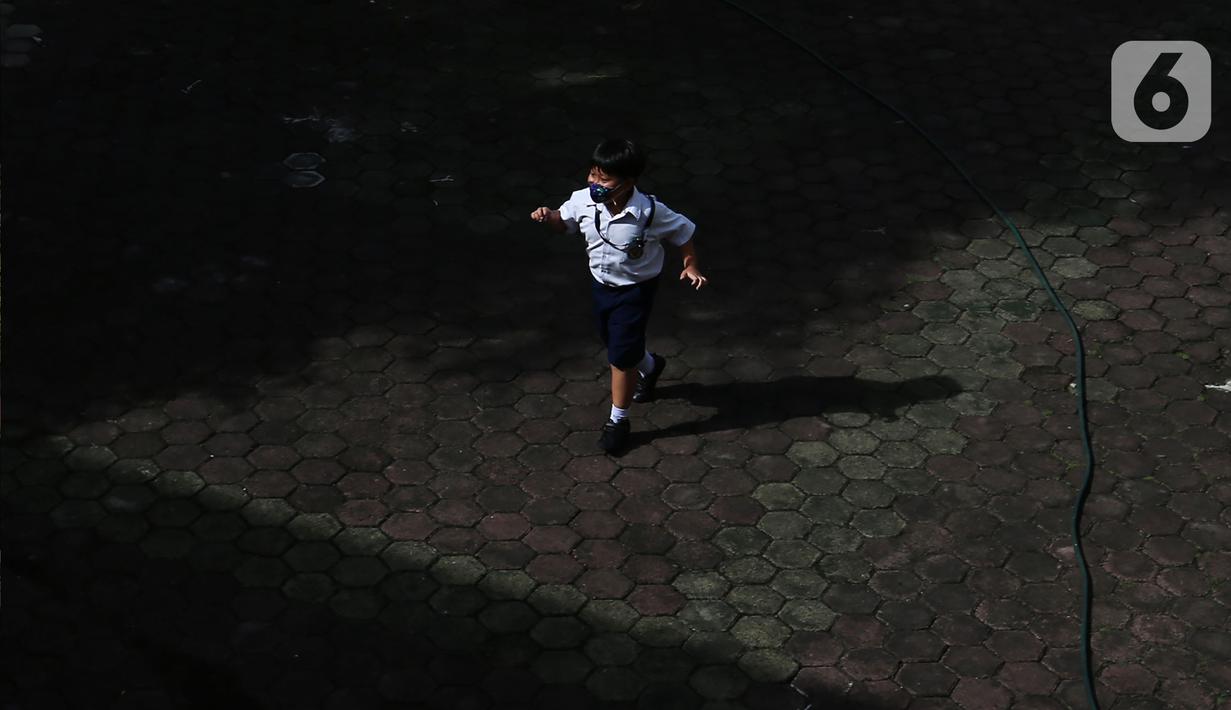 Seorang siswa berjalan di halaman saat pelaksanaan Pembelajaran Tatap Muka (PTM) di SD Pangudi Luhur Jakarta, Rabu (25/5/2022).PPKM level 1 kini diberlakukan untuk wilayah Jakarta dan sekitarnya. Selama PPKM level 1, sekolah di Jabodetabek bisa melangsungkan Pembelajaran Tatap Muka (PTM) 100 persen. (Liputan6.com/Johan Tallo)