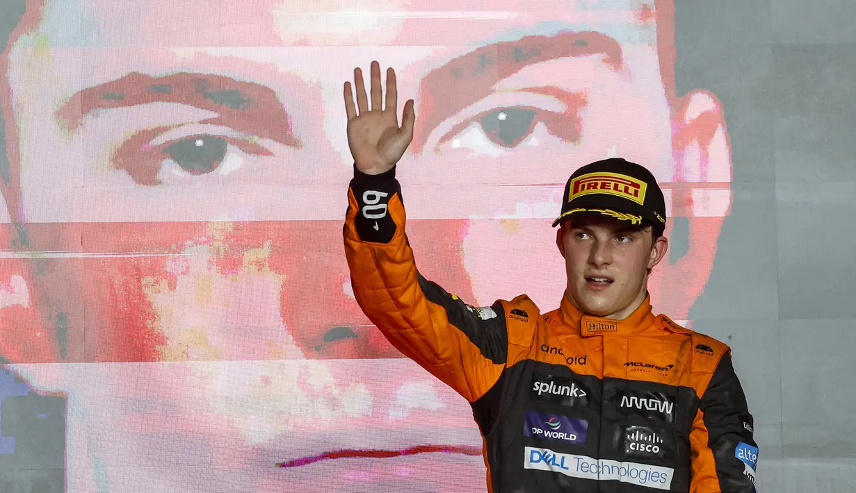 Pembalap McLaren, Oscar Piastri melambaikan tangan di atas podium setelah ajang balap Formula 1 GP Qatar 2023 yang berlangsung di Sirkuit Lusail, Qatar, Minggu (08/10/2023) malam WIB. (AFP/Karim Jaafar)